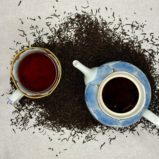 Tea cup and teapot with scattered tea Earl Grey Tea on a textured surface