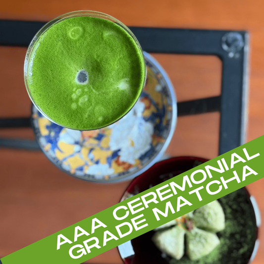 Green ceremonial grade matcha in a glass with a wooden background